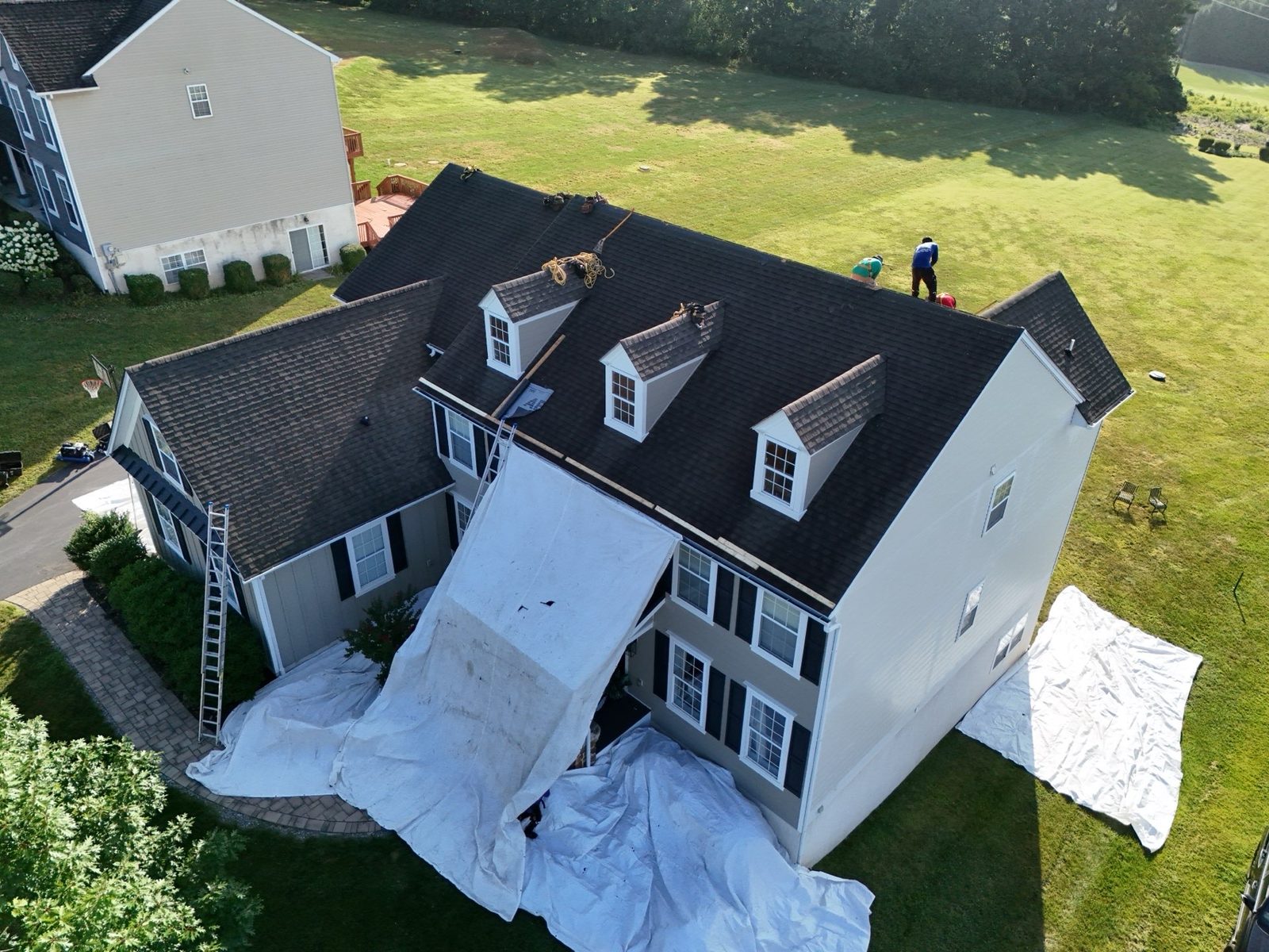 Drone view of a white home with a new black roof in Mohnton, PA